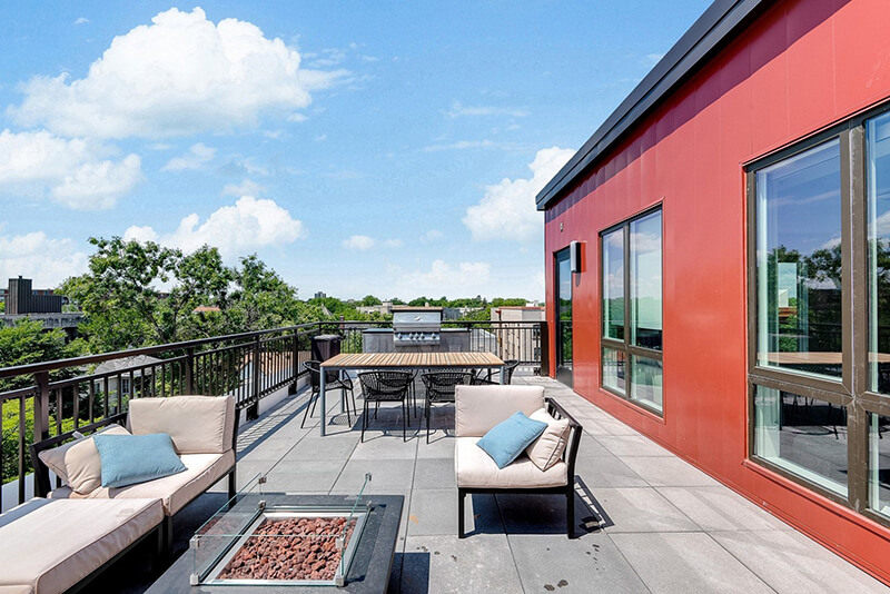 the nox apartment building community balcony with fire pit, grill, and seating