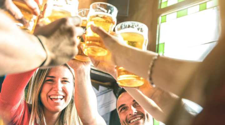 young adults cheersing at the bar